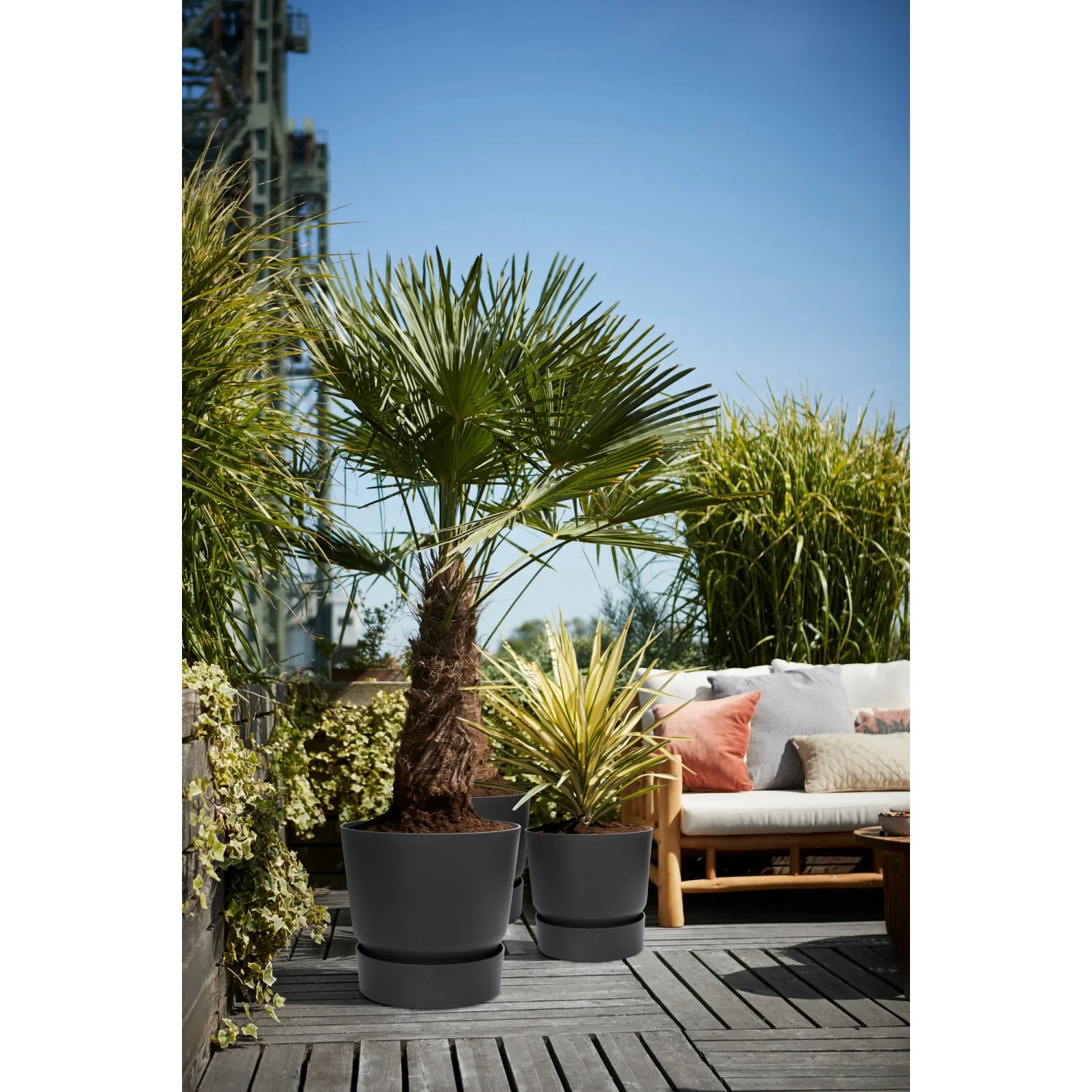 Elho Greenville Pflanzgefäß, rund, Ø 47 cm, schwarz, mit Pflanzen auf einer Terrasse.