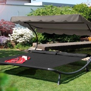 Anthrazitfarbene Leco Doppelliege mit Sonnendach und Kopfkissen im Garten.