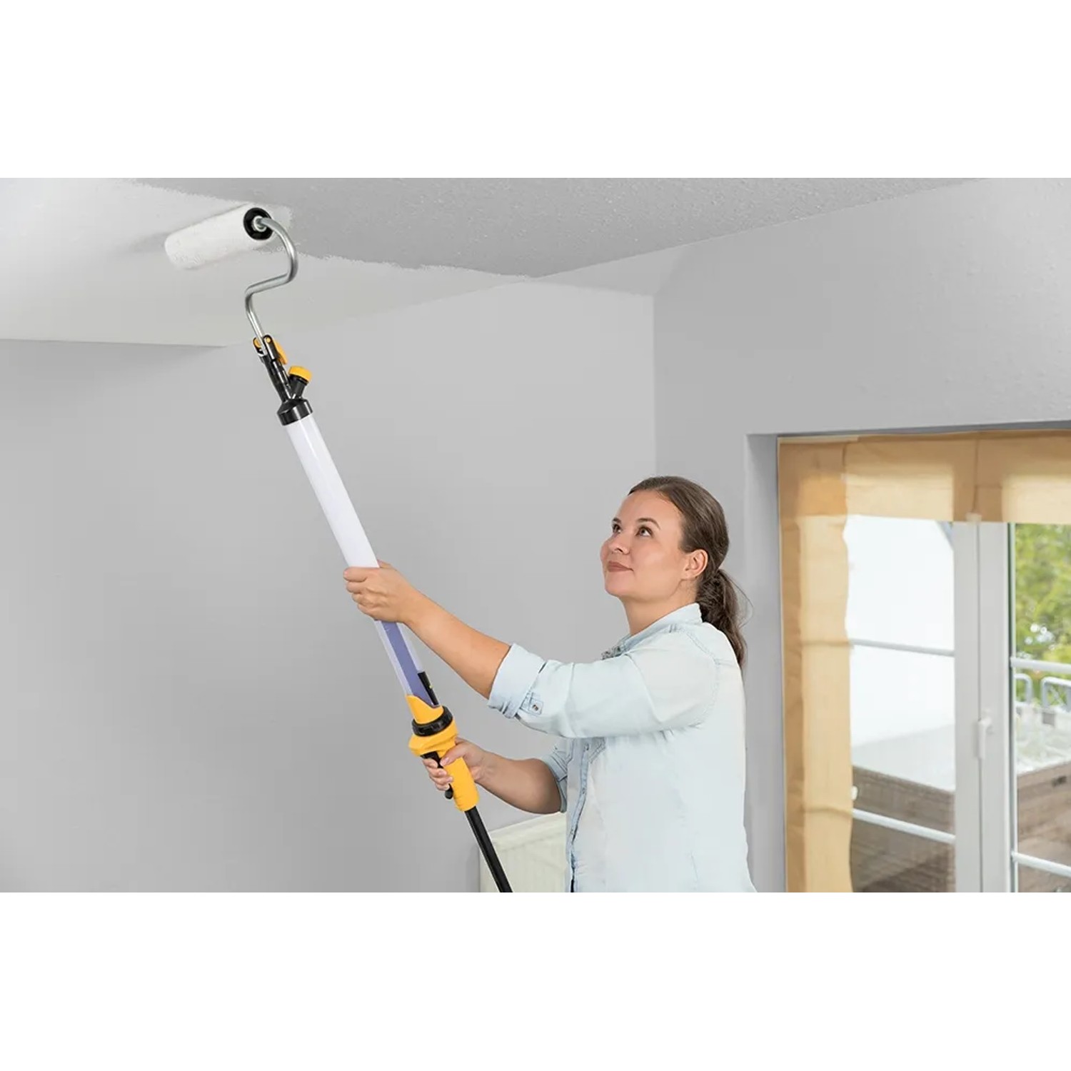 Frau streicht Decke mit Wagner EasyRoll Farbroller 23 cm. Einfache und saubere Anwendung.