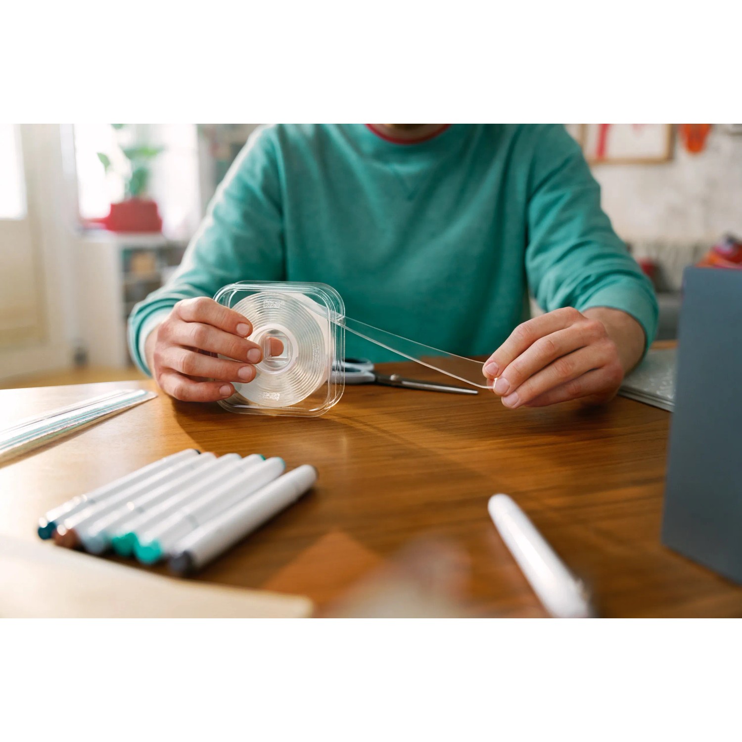 Tesa Universal-Klebeband Doppelseitig mit Nano-Power in Anwendung auf einem Tisch.