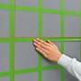 Bosch Quigo Plus Kreuzlinienlaser mit Stativ im Einsatz: Ausrichten von Markierungen an einer Wand.