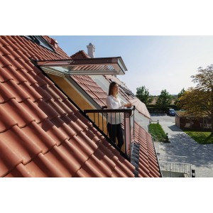 Velux Cabrio Dachfenster geöffnet: Frau steht auf kleinem Dachbalkon mit rotem Ziegeldach.