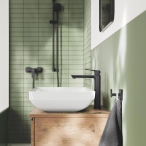 Moderne Grohe Armatur Dice in Mattschwarz auf Holzwaschtisch mit weißem Becken im Bad.