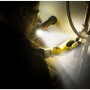 Handwerker mit Energizer Hardcase Arbeitslampe bei Reparaturarbeiten an Rohren.