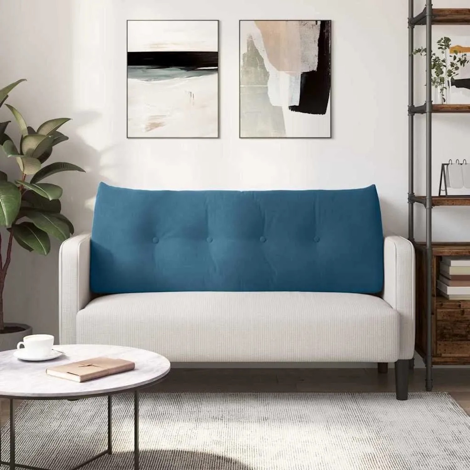 Blaues Samt-Rückenkissen mit Knopfheftung auf hellem Sofa. Bietet Komfort und Unterstützung im Wohnzimmer.