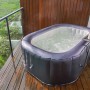 MSpa Urban Whirlpool Nest AirJet mit Hydromassage und Beistelltisch auf einer Terrasse.