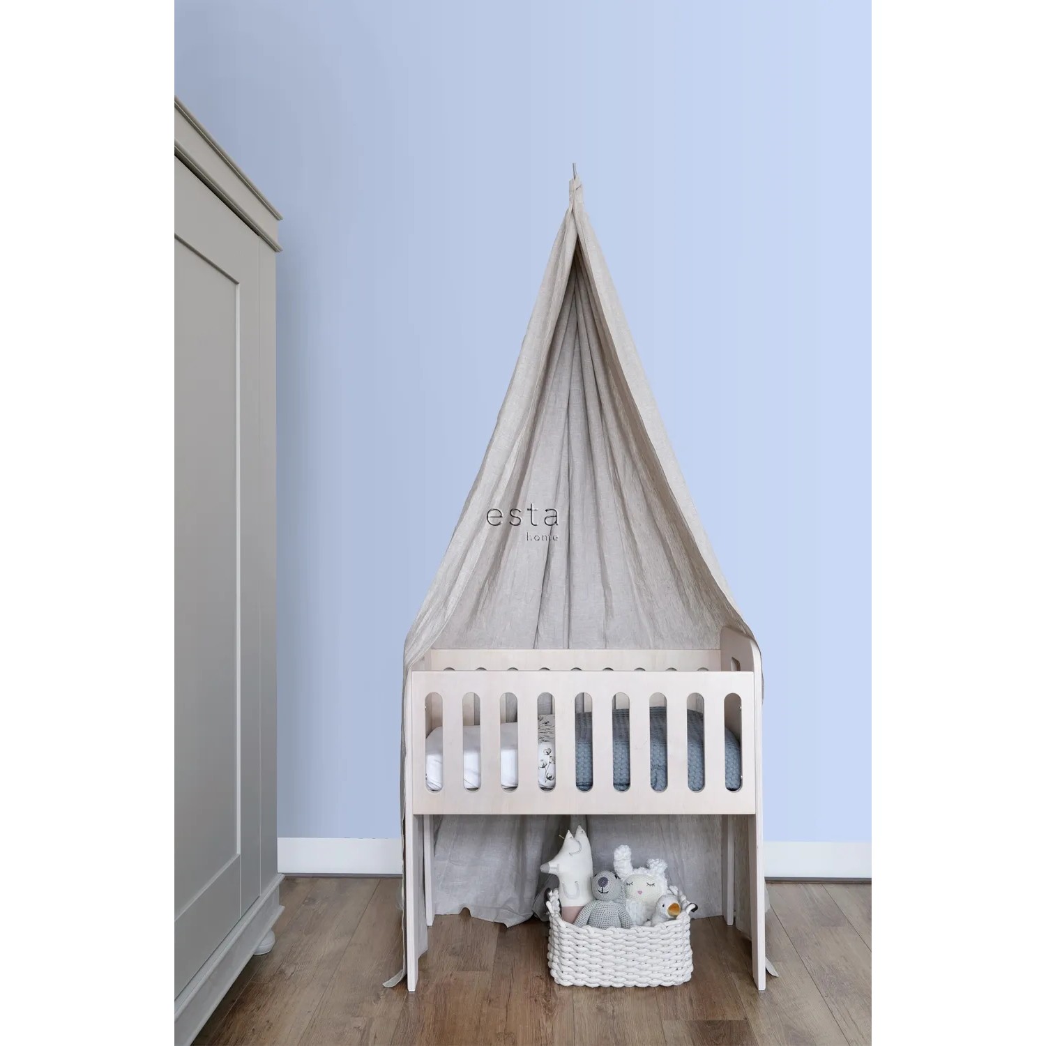 ESTAhome Vliestapete Uni Hellblau im Babyzimmer mit Himmelbett und Spielzeugkorb.