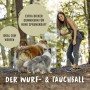 Frau wirft Rudelkönig Hundeball (orange, 6,5 cm) vor zwei Hunden im Wald. Apportierspielzeug.