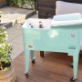 Axi Kühlwagen Retro Mint, 76 l, mit Rollen, Flaschenöffner und Getränken im Garten.
