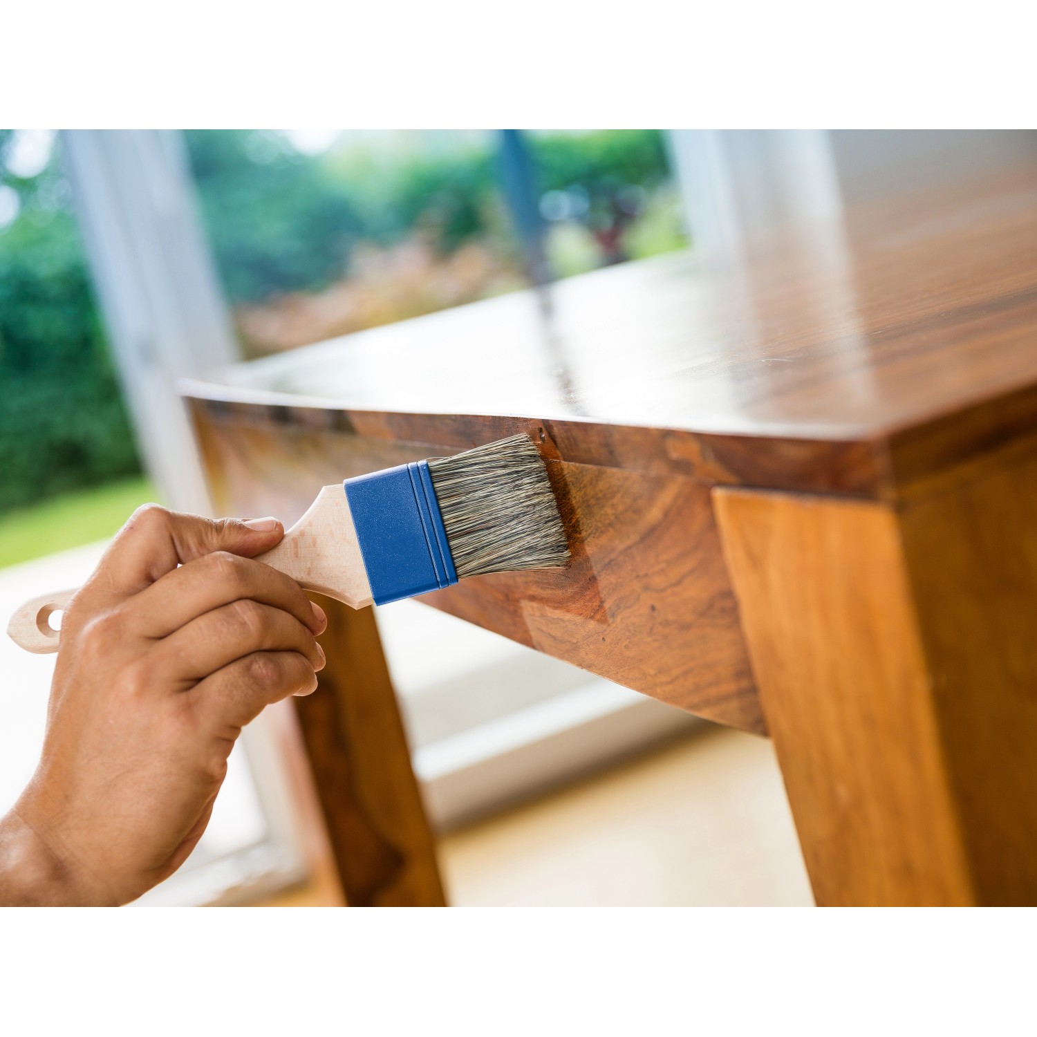 Hand ölt Holztisch mit LUX Wachspinsel 50mm. Pinsel mit blauem Kopf und hellem Holzgriff.
