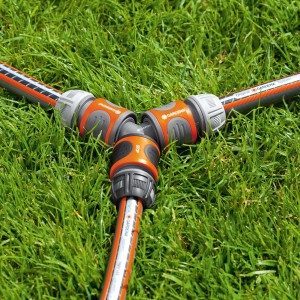 Gardena Y-Stück zur Schlauchabzweigung auf Rasen, orange/grau.