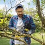 Mann arbeitet mit gelber Kärcher Akku-Kettensäge CNS 18-30 Battery an Baum im Garten.