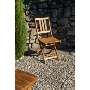 Zusammengeklappter SAM Balkonstuhl BLOOM aus Akazienholz im Garten.
