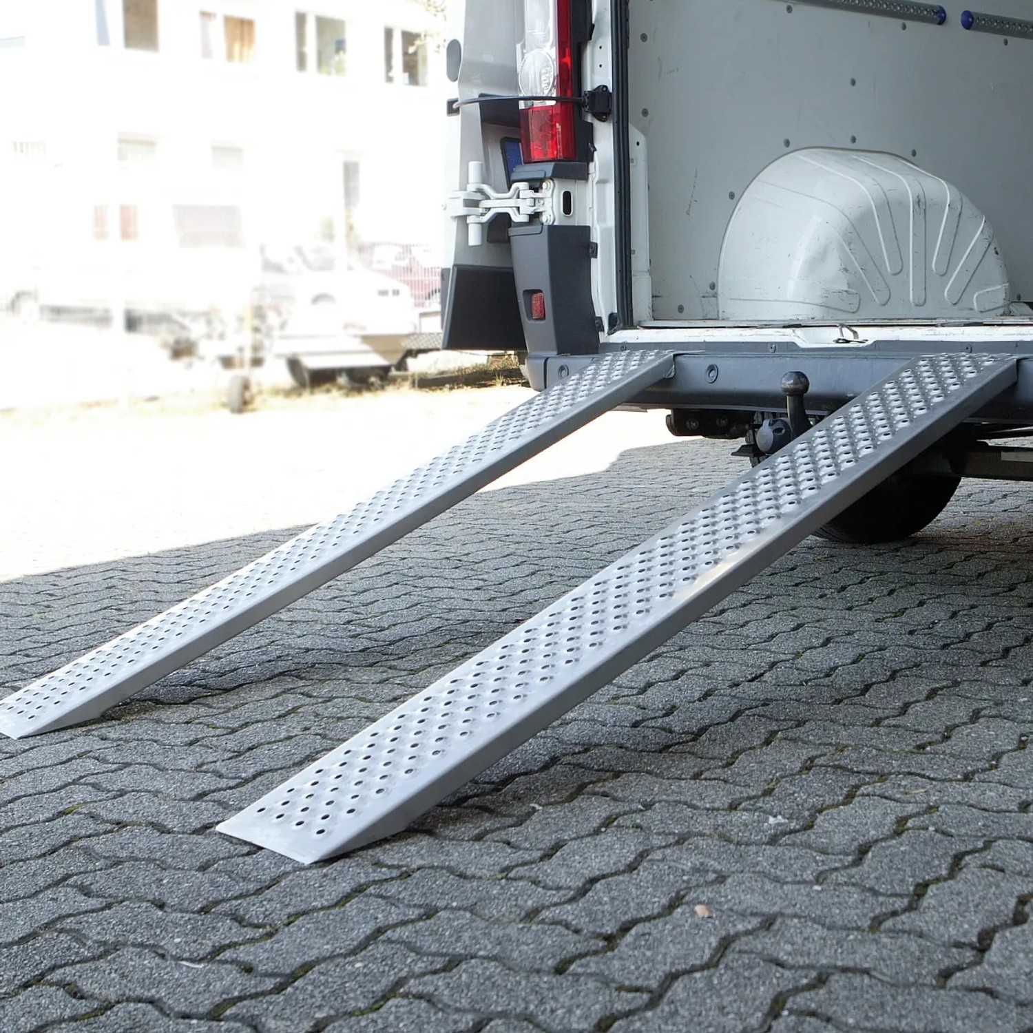 Auffahrrampen aus Aluminium, 2 Stück, angelegt an einen Transporter zum Verladen.