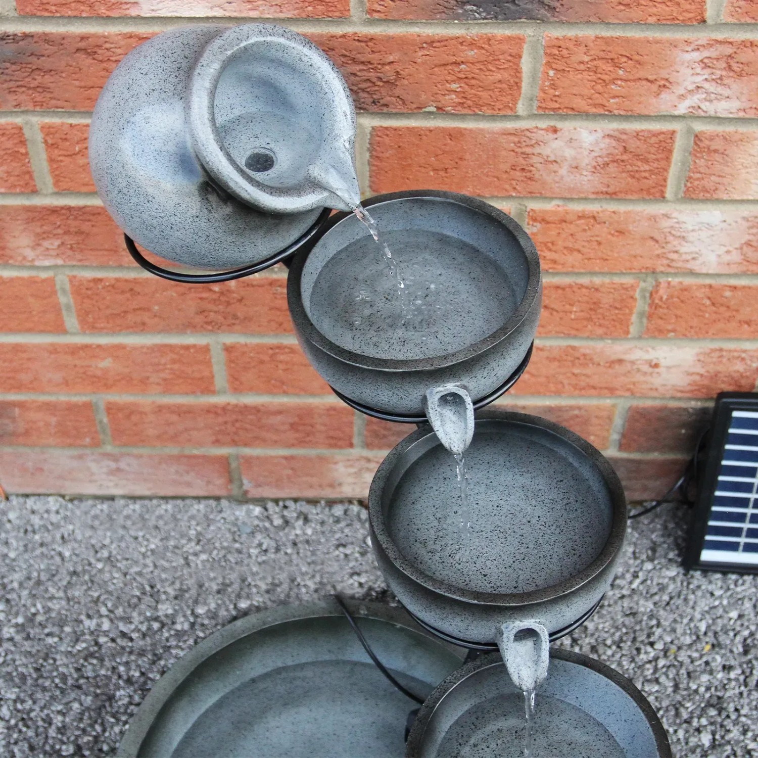 Grauer Solar Kaskadenbrunnen von Monstershop, mehrstufig mit Wasserlauf und Solarpanel.