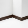 Parador Sockelleiste SL 4 Eiche D047, 60mm hoch, dunkles Holzdekor an weißer Wand.