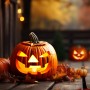 Leuchtender Halloween Kürbis mit geschnitztem Gesicht und Blättern als stimmungsvolle Außendekoration.
