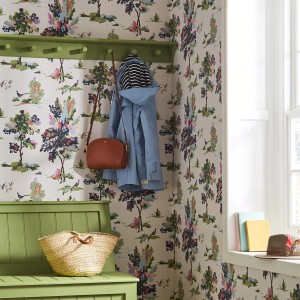 Raum mit Joules Vliestapete Woodland Scene Dawn Grey mit Waldmotiv, grüner Bank und Garderobe.