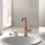 Grohe Essence Waschtischarmatur L-Size in Warm Sunset gebürstet auf einem Waschbecken.