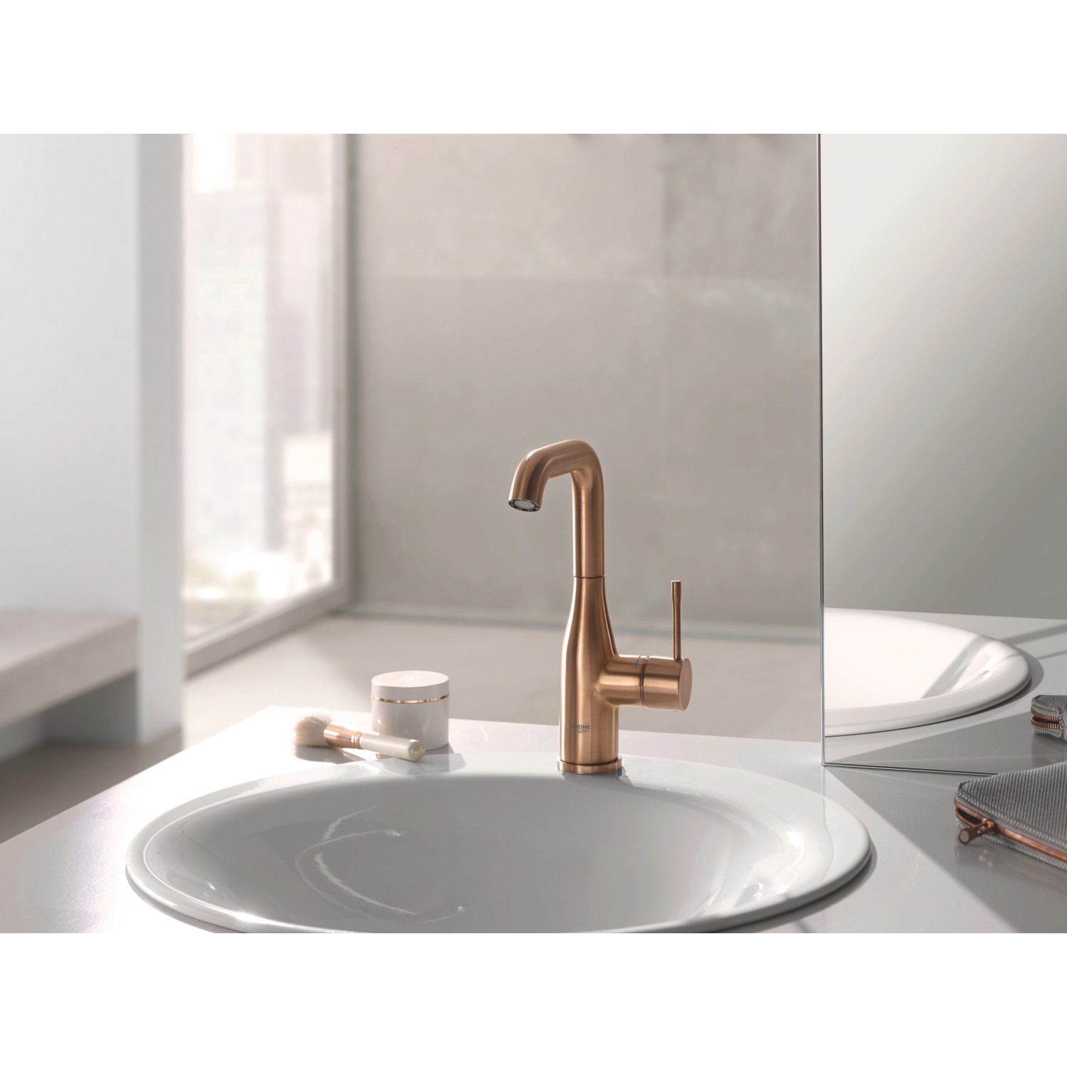 Grohe Essence Waschtischarmatur L-Size in Warm Sunset gebürstet auf einem Waschbecken.