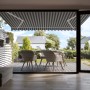 Gelenkarmmarkise Aventura, 4x2,5m, grau-weiß gestreift, montiert über einer Terrasse mit Gartenmöbeln.
