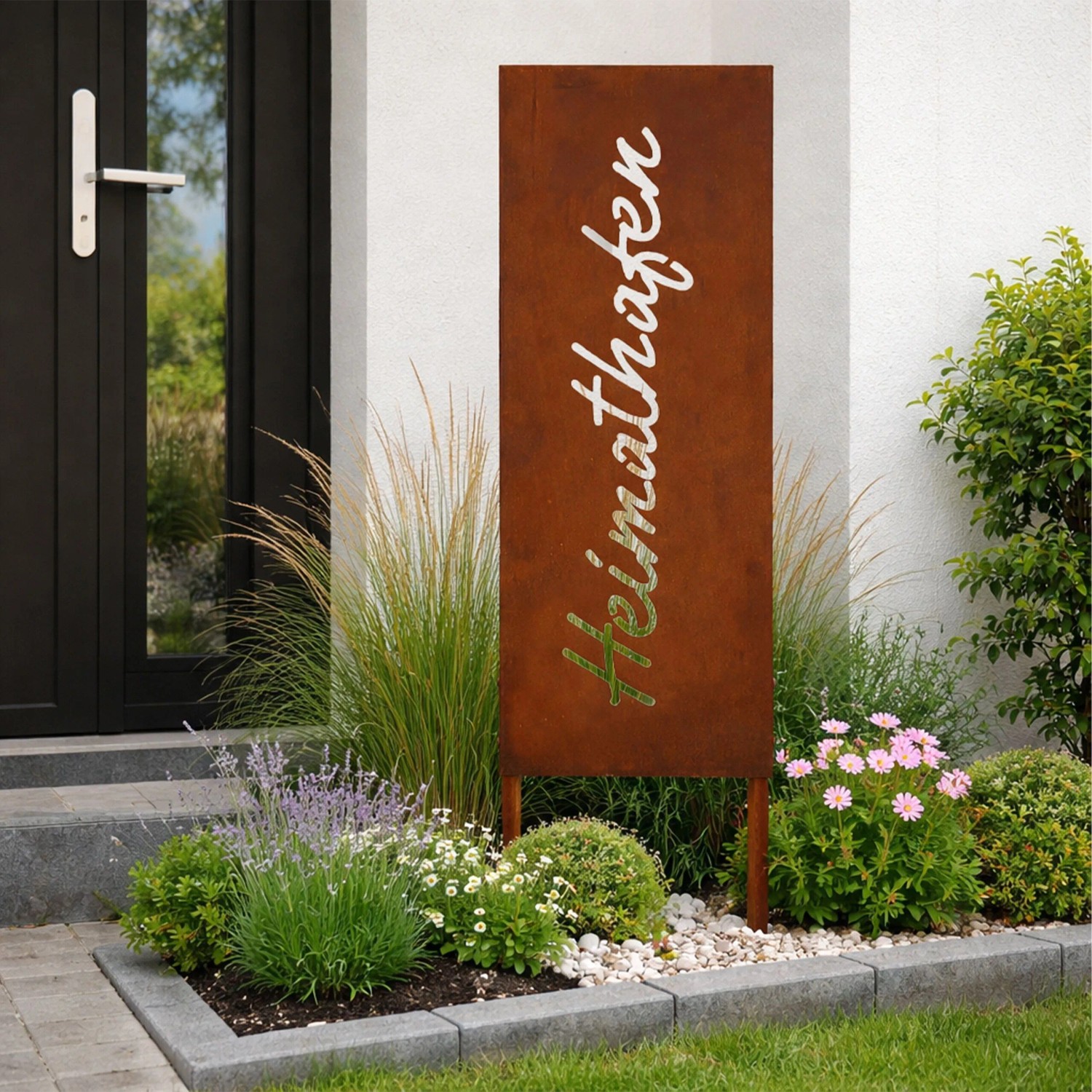 Rostbrauner Gartenstecker aus Eisen mit 'Heimathafen' Schriftzug, 115 cm hoch, als Dekoration im Blumenbeet.
