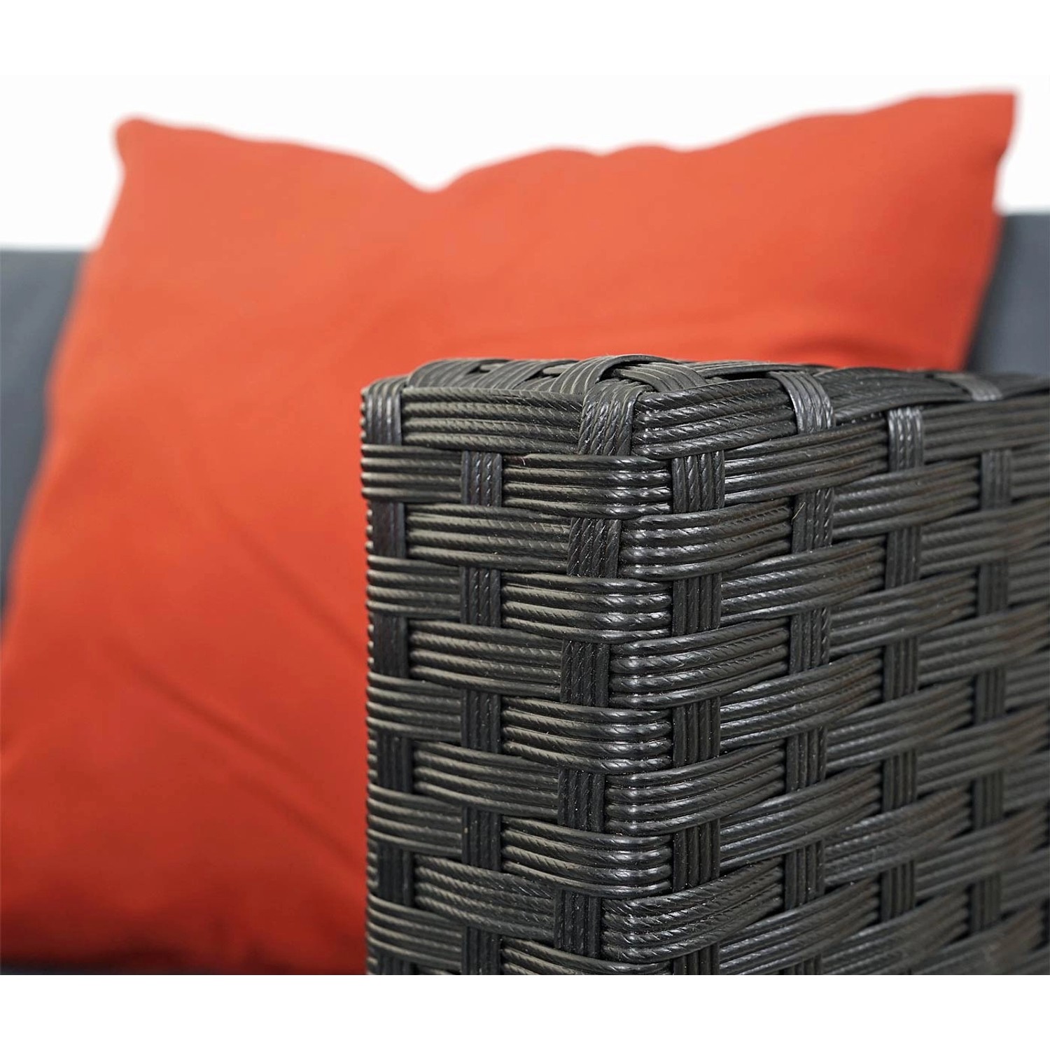 Detailansicht: Schwarze Poly-Rattan Lounge-Garnitur mit terracottafarbenem Kissen.