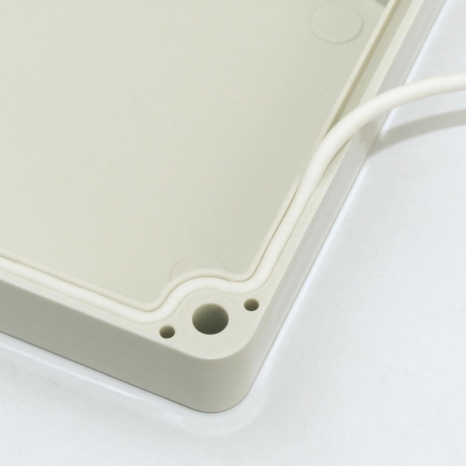 Lichtgraues Blanko Modulgehäuse IP65, 160x110x90mm, Detailaufnahme der Dichtung und Schraublöcher.