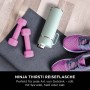 Mintfarbene Ninja Thirsti Trinkflasche (530ml) mit Hanteln und Sportschuhen auf einer Yogamatte.