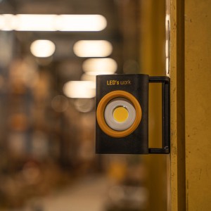 LED-Akku-Arbeitsleuchte mit Magnetfuß an Metall befestigt.