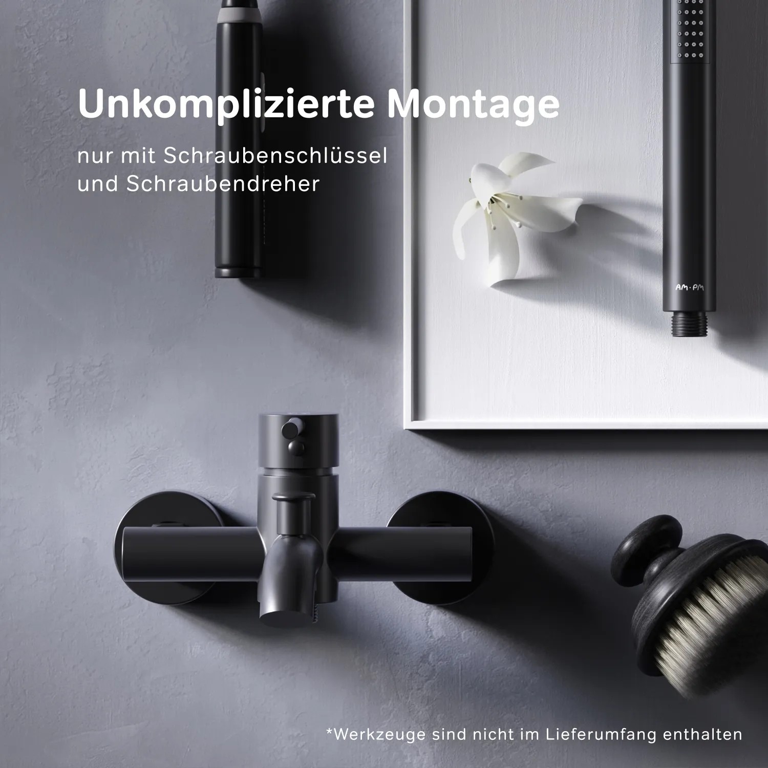 Schwarze AM.PM Wannenarmatur Spike Aufputz mit Brausegarnitur vor grauer Wand.