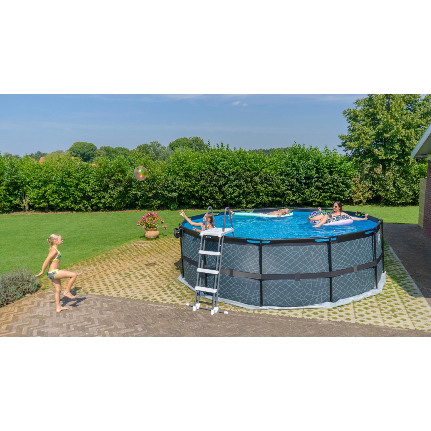Exit Black Leather Pool, ø 450 cm, mit Leiter und Sandfilterpumpe. Stahlrahmenpool mit Personen im Wasser.