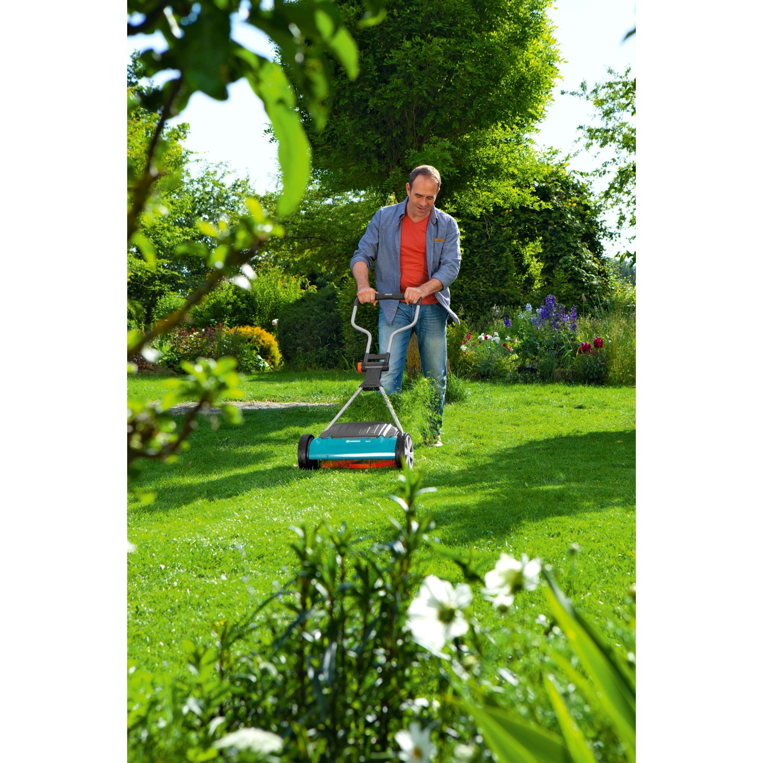 Mann mäht Rasen mit Gardena Comfort Spindelmäher 400 C. Handrasenmäher für präzisen Schnitt.