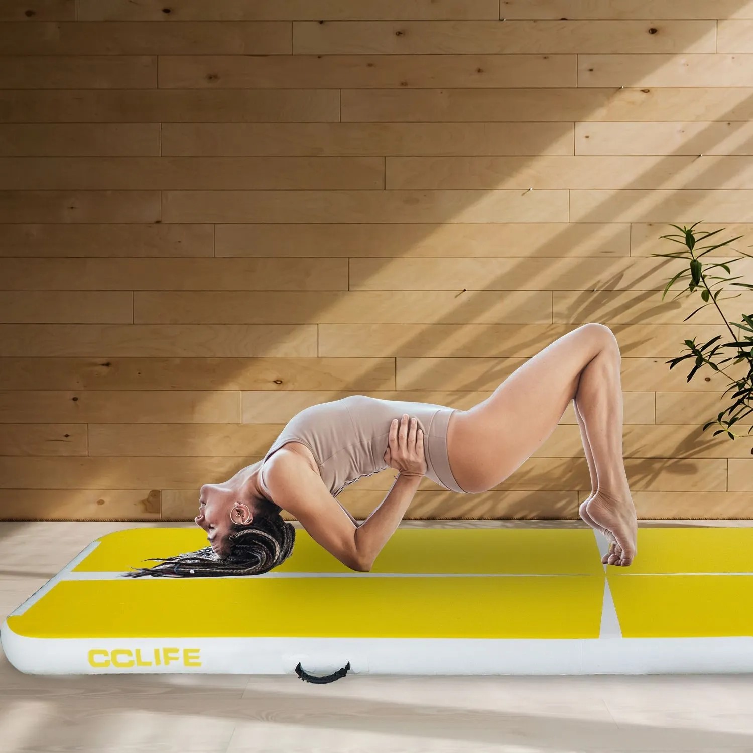 Gelbe CCLIFE Airtrack Matte mit turnender Frau. Aufblasbare Gymnastikmatte für Fitness & Training.