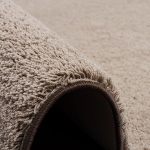 Detailaufnahme: Flauschiger, taupefarbener Snapstyle Hochflor Teppich Palace (200x250cm) mit braunem Rand.