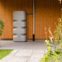 Garantia Gartentank Cubus 1000 l in Betongrau vor einer Holzwand. Regentonne für Garten.