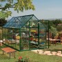 Grünes Palram Canopia Gewächshaus 5,7 m² mit Fundamentrahmen im Garten.