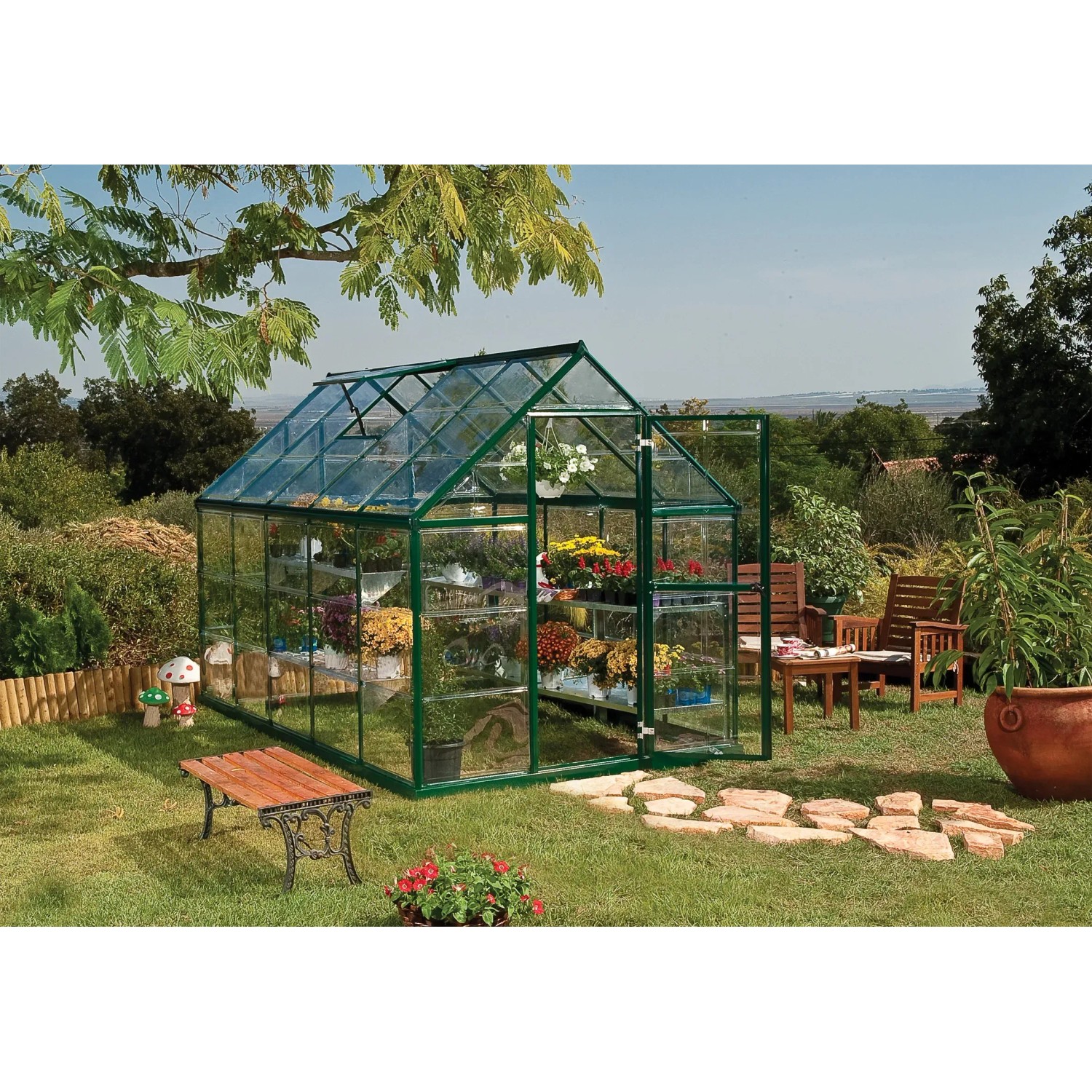 Grünes Palram Canopia Gewächshaus 5,7 m² mit Fundamentrahmen im Garten.