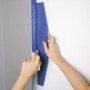 Anwendung des LUX Beschneidelineals 60 cm beim Malen einer Wand mit blauem Farbanstrich.