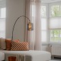 Elegante QAZQA Bogenlampe Zuzanna in Schwarz und Gold mit Rauchglas-Schirm im Wohnraum.