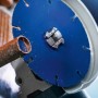Bosch Expert Carbide Multi Wheel Trennscheibe (Ø 125 mm) beim Schneiden eines Rohrs mit einem Winkelschleifer.
