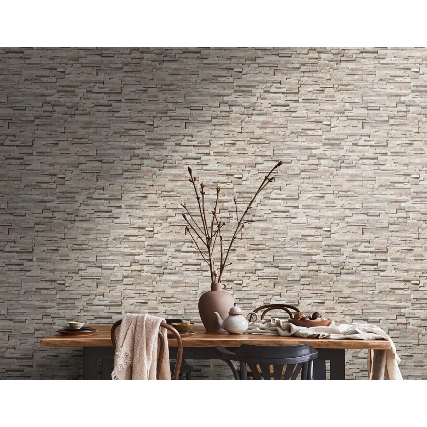 AS-Creation Vliestapete Steinoptik beige-braun an Wand hinter Esstisch.