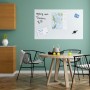 Weißes Relaxdays Glas Magnetboard 100x60 cm an grüner Wand mit Notizen. Ideal für Büro und Küche.