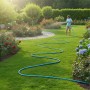 Hellblauer Relaxdays Gartenschlauch (20m) im Einsatz zur Gartenbewässerung.