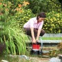 Frau bedient Al-Ko Schmutzwassertauchpumpe Drain 10.000 Comfort am Gartenteich.