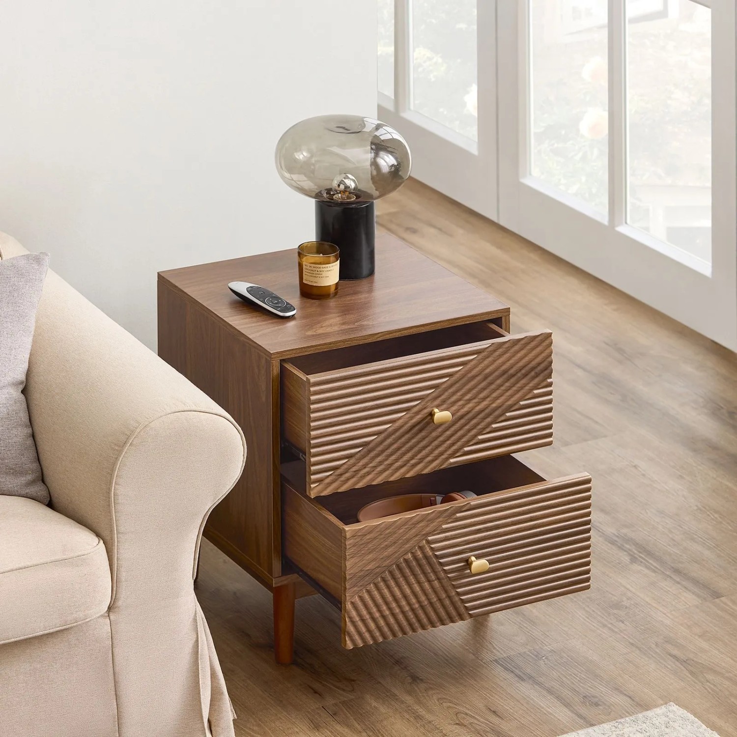 Brauner Vintage Nachttisch mit 2 geriffelten Schubladen und goldenen Griffen, neben Sofa.