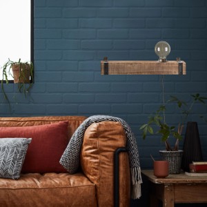 Wandleuchte Woodhill in Schwarz/Holz mit Zuleitung und Schalter an blauer Backsteinwand.
