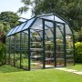 Grünes Palram Canopia Gewächshaus mit Fundamentrahmen im Garten.