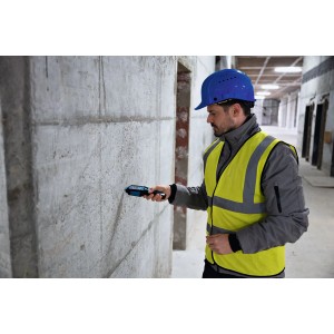 Handwerker misst Feuchtigkeit in Betonwand mit Bosch Professional Materialfeuchtemessgerät.
