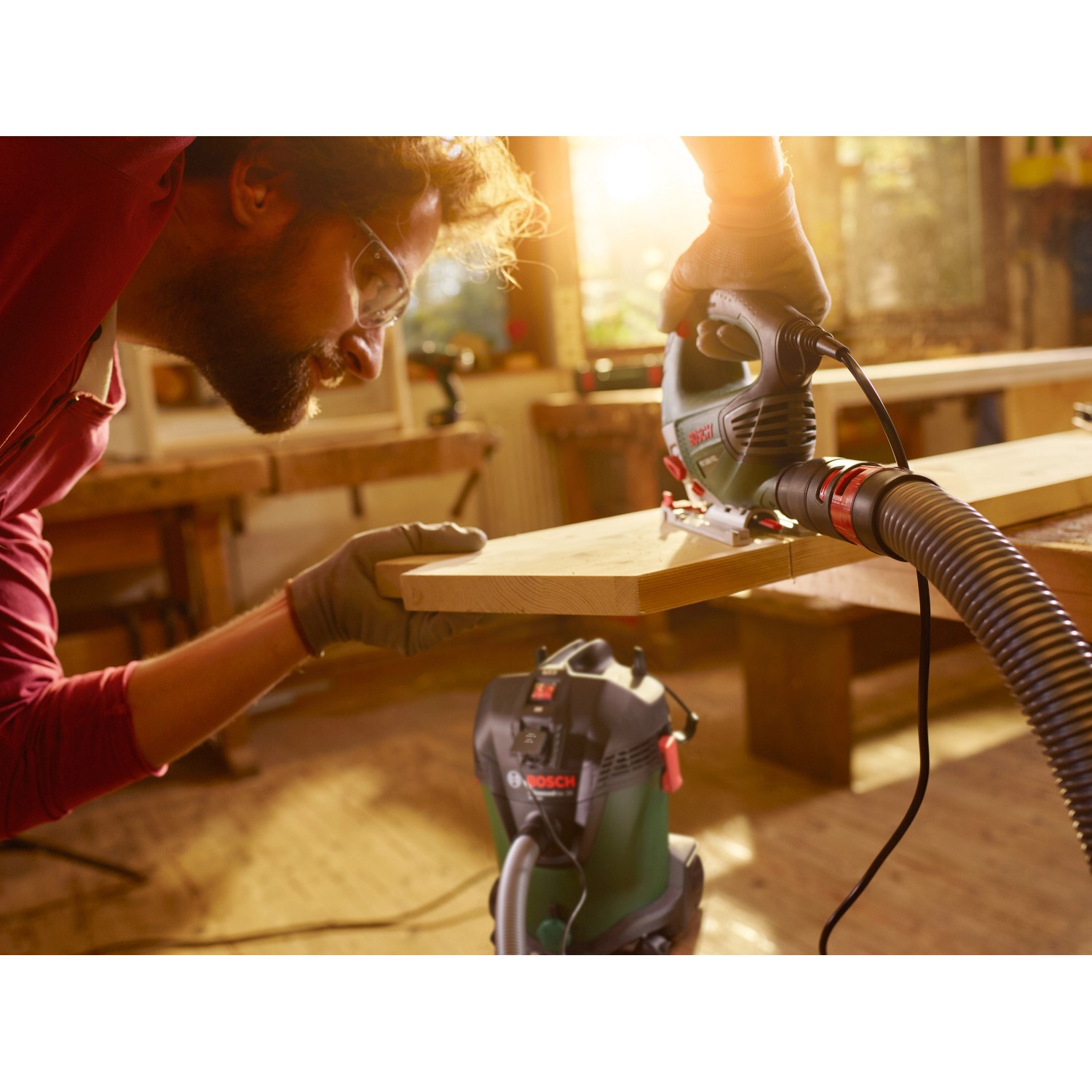 Bosch AdvancedVac 20 Nass- und Trockensauger im Einsatz mit Stichsäge an Holzbrett.